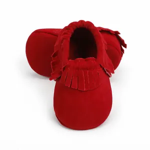 Detailansicht weicher roter Wildleder-Babyschuhe mit dekorativen Fransen für Neugeborene