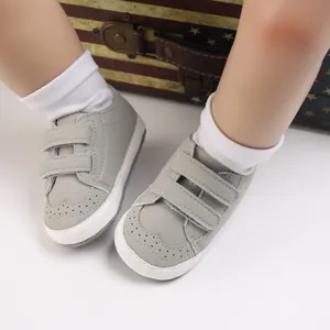 Close-up view of grey baby soft sole walking shoes with secure velcro straps for infants