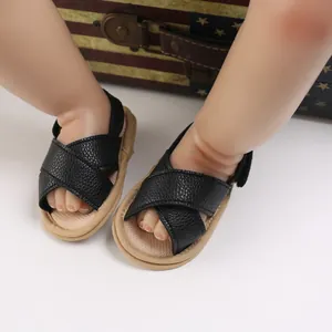Vista detallada de sandalias negras transpirables para bebé con suelas blandas en modelo