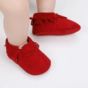 Nahaufnahme von roten Baby-Lauflernschuhen aus Wildleder mit modischen Fransen-Details