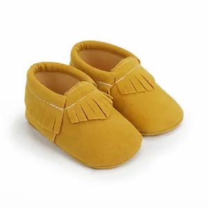 Detailaufnahme von gelben Wildleder-Babyschuhen mit Fransen und weicher Sohle