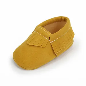Nahaufnahme der weichen gelben Wildleder-Babyschuhe mit eleganten Fransen-Details