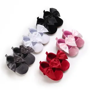Vue détaillée de chaussures de princesse pour bébé en velours avec nœuds en satin colorés