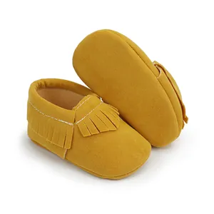 Detailansicht der gelben Wildleder-Babyschuhe mit stilvollem Fransen-Quasten-Design
