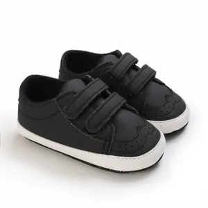 Close-up detail of black infant walking shoes with soft soles and velcro straps