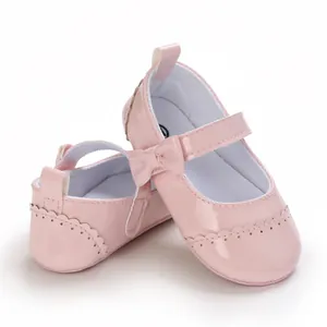 Detail view of pink patent leather baby girl princess walking shoes with a sweet bow