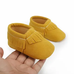 Gelbe Baby-Mokassins mit Fransen, weiche Krabbelschuhe für Neugeborene im Detail.