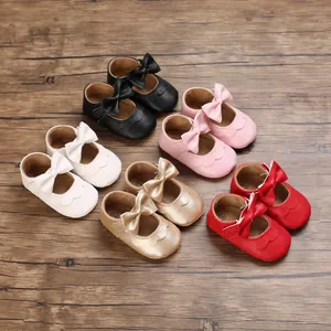 Detailaufnahme von fünf Paar Baby-Lernschuhen mit Schleifen in verschiedenen Farben.