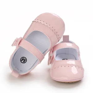 Close-up detail of pink patent leather baby princess walker shoes with bow decoration
