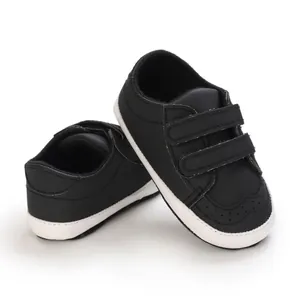 Detailed macro view of black infant soft sole walking shoes with double velcro straps