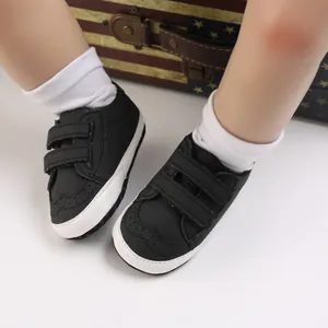 Detailed view of baby soft sole walking shoes with velcro straps and brogue patterns.
