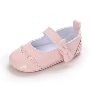 Detailed close-up of a pink patent leather baby princess shoe with a delicate bow.