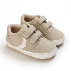 Primer plano de la textura de lona beige y el cierre de velcro doble de zapatos para bebés