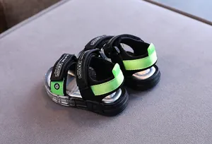 Detaillierte Makroansicht sportlicher schwarzer und neongrüner Jungen-Sandalen Klett