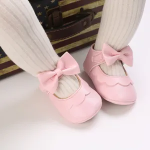 Detaillierte Nahaufnahme rosa Babyschuhe mit einer süßen Schleife und Wellenrand