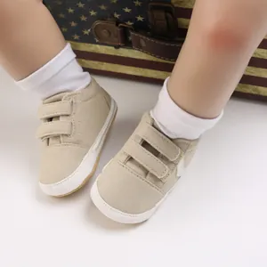 Primer plano detallado de zapatos beige para bebé con suela blanda y cierre de velcro