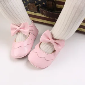 Nahaufnahme der rosa Baby-Prinzessin-Schuhe mit eleganter Schleife und Wellenrand-Design