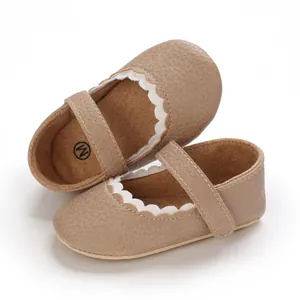 Detailansicht von braunen Baby-Lauflernschuhen mit weißem Wellenrand aus Kunstleder
