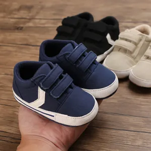 Vista detallada de zapatos para caminar de bebé azul marino con suelas blandas y velcro.
