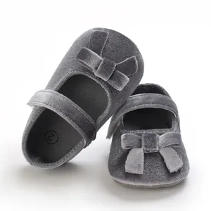 Detailansicht von eleganten grauen Baby-Samtschuhen mit weichen Sohlen und Schleifendetails