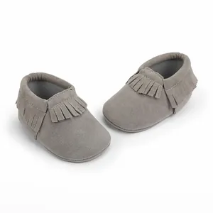 Detailansicht hochwertiger grauer Wildleder-Babyschuhe mit Fransen für neugeborene Mädchen.