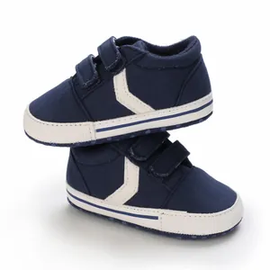 Detalle de zapatillas de deporte azul marino para bebé con suela blanda y cierre velcro.