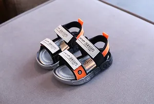 Nahaufnahme von Jungen-Sportsandalen mit orangen Akzenten und Klettverschlüssen
