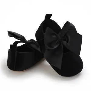 Vue détaillée de chaussures de princesse en velours noir pour bébé avec grands nœuds