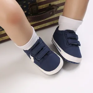 Detalle de zapatillas de lona azul marino para bebé con tiras de velcro dobles y suela blanda