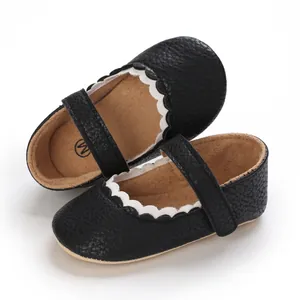 Nahaufnahme von schwarzen Baby-Prinzessin-Lauflernschuhen mit weißem Wellenrand