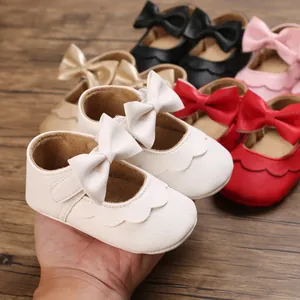 Nahaufnahme von Baby-Prinzessinenschuhen mit großer Schleife und Wellenrandverzierung