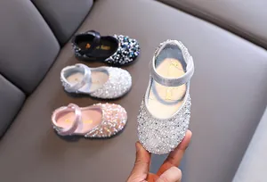 Macro detail of sparkly rhinestone girls' Mary Jane flat shoes in silver finish