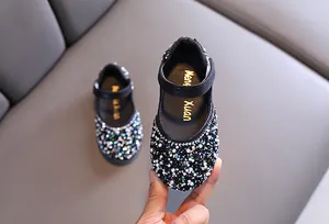 Close-up of sparkling rhinestone and pearl embellishments on girl's Mary Jane shoes