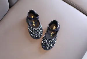 Detailed view of girls' black Mary Jane shoes adorned with sparkling colorful rhinestones