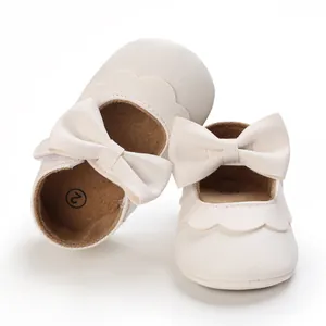 Nahaufnahme von weißen Baby-Lauflernschuhen mit weicher Sohle, Schleife und Wellenrand