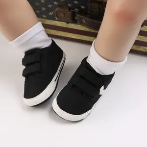 Primer plano de zapatos de bebé negros con suela blanda y velcro