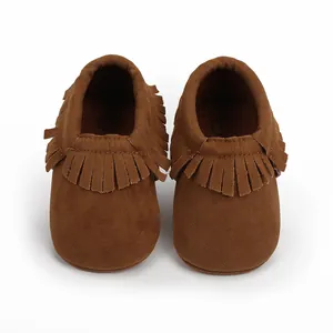 Detailaufnahme von braunen Wildleder-Babyschuhen für Neugeborene mit Fransen-Akzenten
