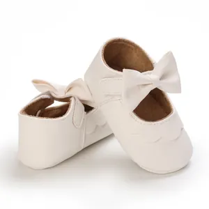 Detailansicht der weichen weißen Baby-Prinzessinenschuhe mit einer dekorativen Schleife