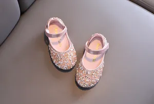 Detail of pink girls' Mary Jane shoes covered in sparkling rhinestones and pearls.