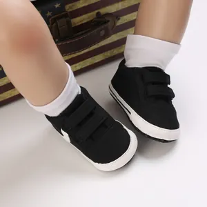 Primer plano de zapatos de lona negros para bebé con suela blanda y cierres de velcro