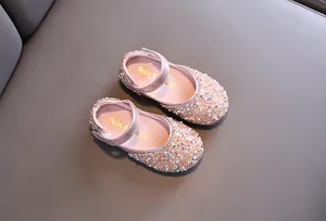 Detailed top view of sparkling pink toddler shoes with rhinestones and pearls.