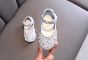 Detailed view of girls' silver dress shoes embellished with sparkly rhinestones and faux pearls