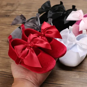 Vue détaillée de chaussures de princesse pour bébé en velours rouge avec grand nœud en satin