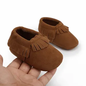 Detailansicht weicher brauner Baby-Mokassins aus Wildleder mit modischen Fransenverzierung