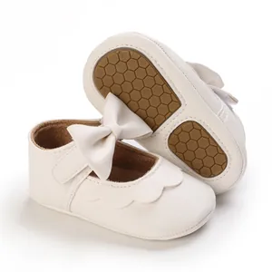 Nahaufnahme von Babylauflernschuhen mit weicher Waben-Gummisohle und Schleife
