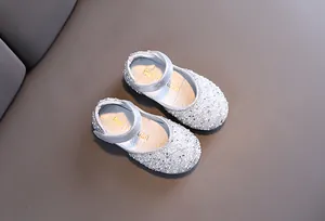 Detailed view of sparkly silver rhinestone-covered dress shoes for little girls