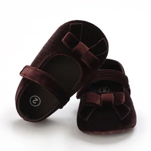 Detailansicht von Baby-Samtschuhen mit weichen Sohlen und schickem Schleifendetail.