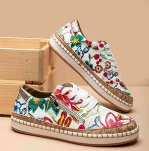 Detail of women's ethnic floral platform sneakers with side zipper and cork sole.