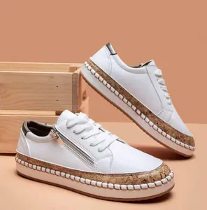 Detailed side view of white platform sneakers with cork trim and side zipper detail