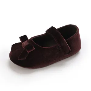 Detaillierte Nahaufnahme weicher Baby-Mary-Jane-Schuhe aus Samt in Dunkelrot mit Schleife